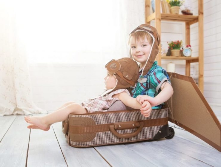 dos niños sentados en una valija
