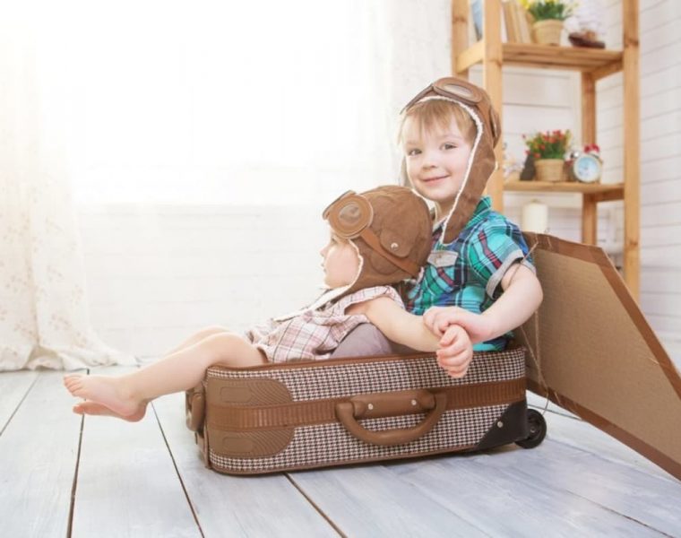 dos niños sentados en una valija