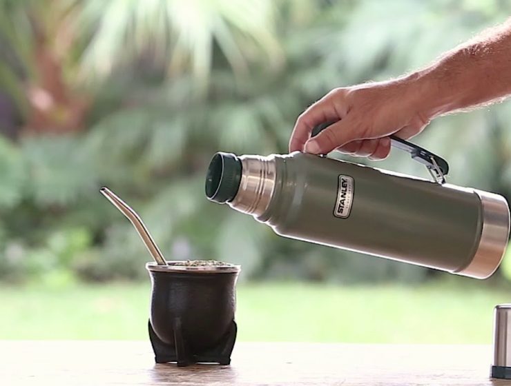 Foto de termo Stanley y una persona cebando mate al aire libre