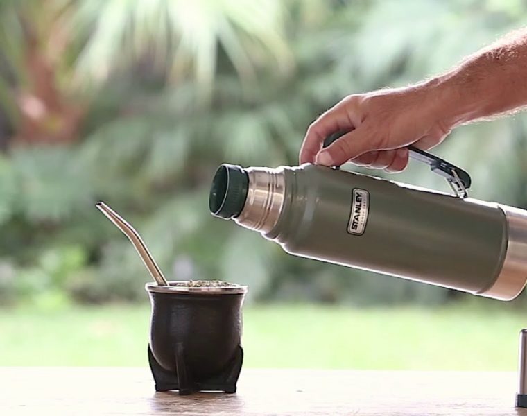 Foto de termo Stanley y una persona cebando mate al aire libre
