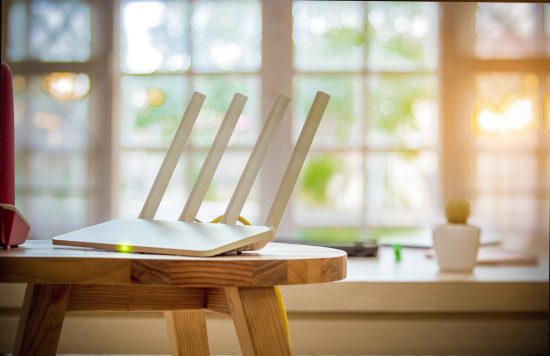 El router es como el administrador del tráfico, asegurando que internet llegue a cada rincón de tu hogar. Router con 4 antenas ubicado sobre una mesa en un hogar