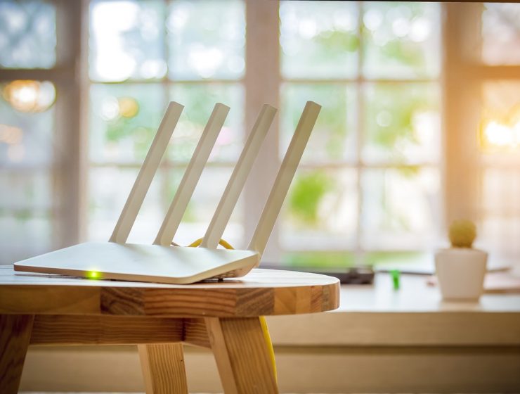 Router con 4 antenas ubicado sobre una mesa en un hogar