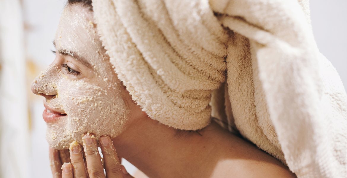 Mujer joven exfoliando su rostro con espuma limpiadora