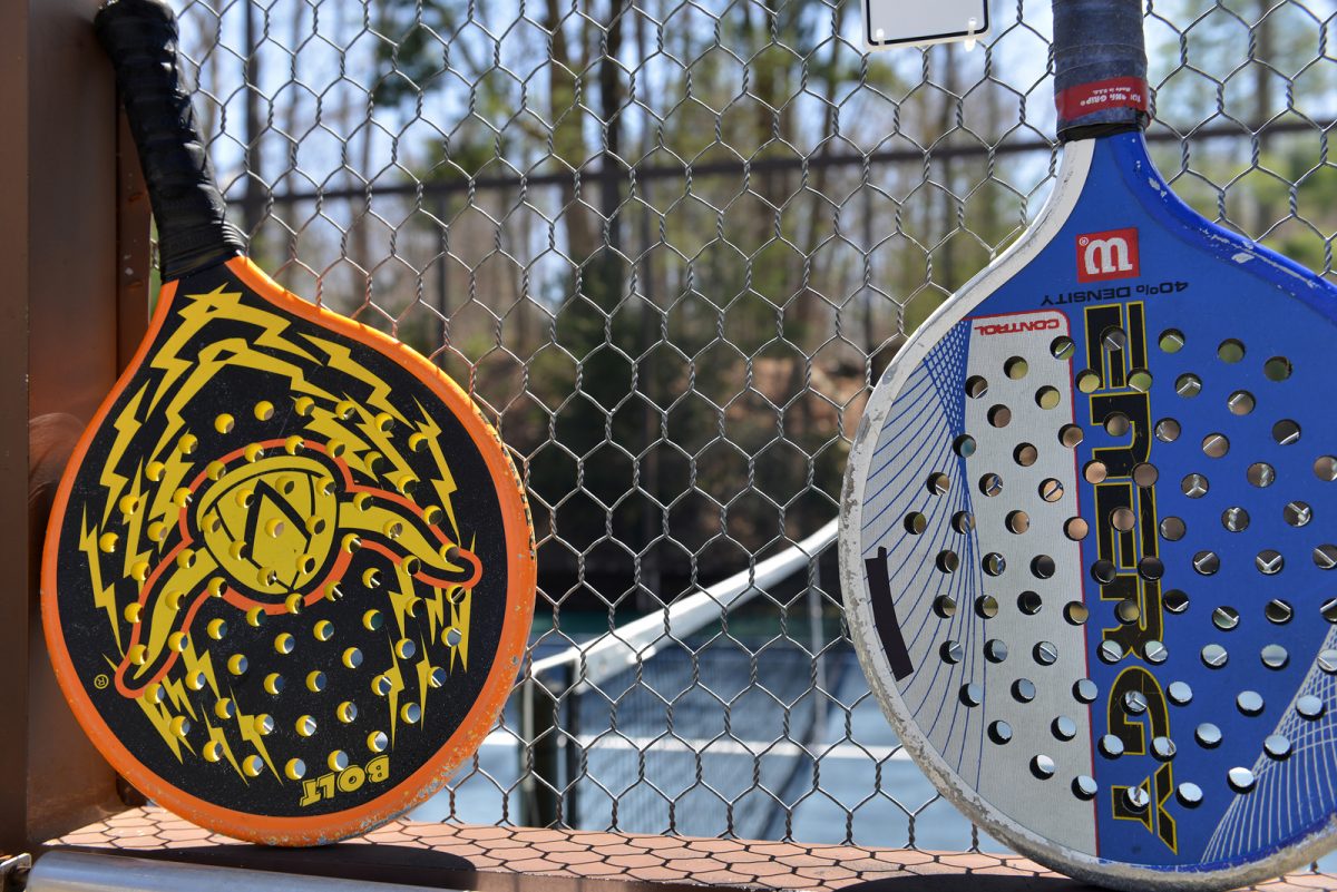 Dos palas de padel Wilson sobre el alambrado de la cancha