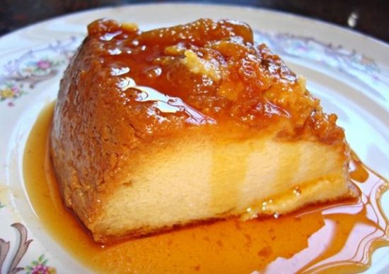 Porción de un cremoso flan napolitano casero bañado en una abundante salsa de caramelo dorado, listo para comer.