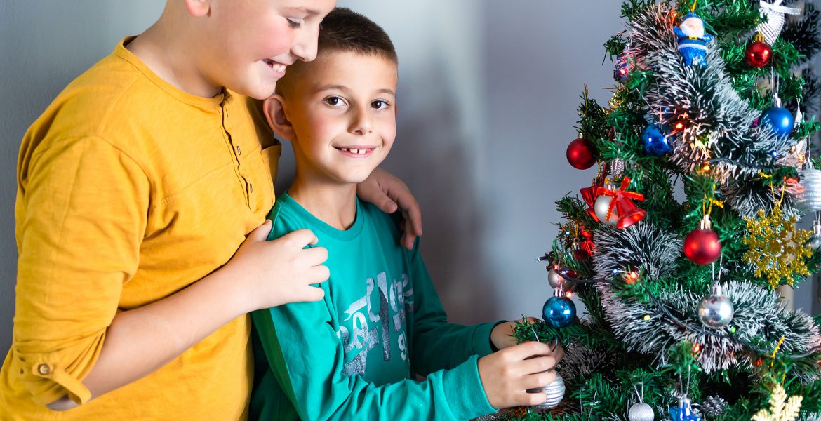 Familia decorando el arbol de Navidad 2025