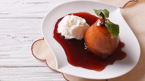 Postre argentino: pera al vino tinto con helado Pera al vino tinto con salsa y helado de crema