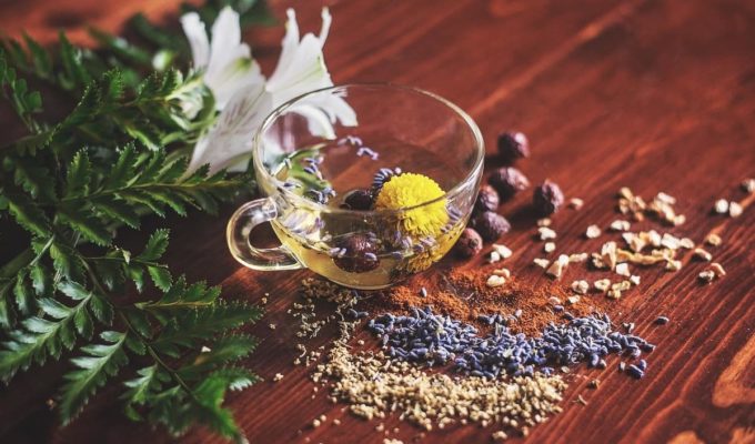 Taza de té con hierbas, especias y flores para preparar blends caseros