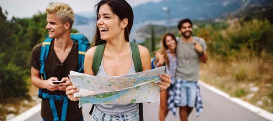 Grupo de amigos jóvenes y felices de excursión, representando la inspiración de viajes en pareja o con amigos que se encuentra en Instagram.