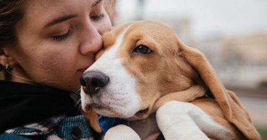 Mujer abrazando a su perro viejito