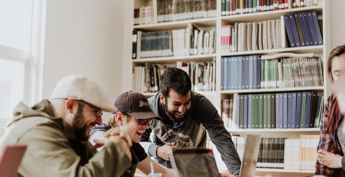 Jóvenes estudiantes trabajando en equipo en una biblioteca, ejemplo de desarrollo de habilidades socioemocionales.
