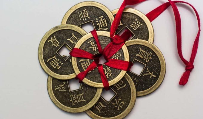 Monedas chinas antiguas atadas con una cinta roja, símbolo tradicional de prosperidad y buena fortuna.