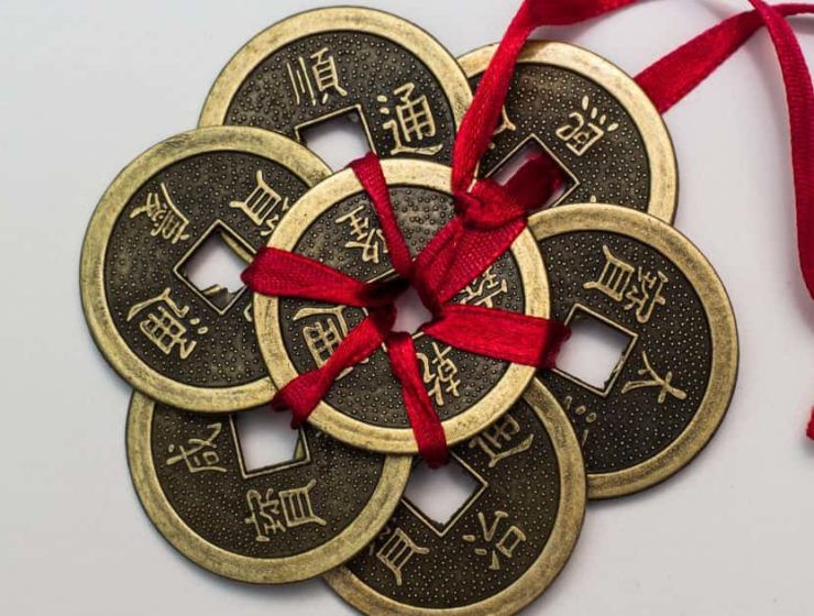 Monedas chinas antiguas atadas con una cinta roja, símbolo tradicional de prosperidad y buena fortuna.