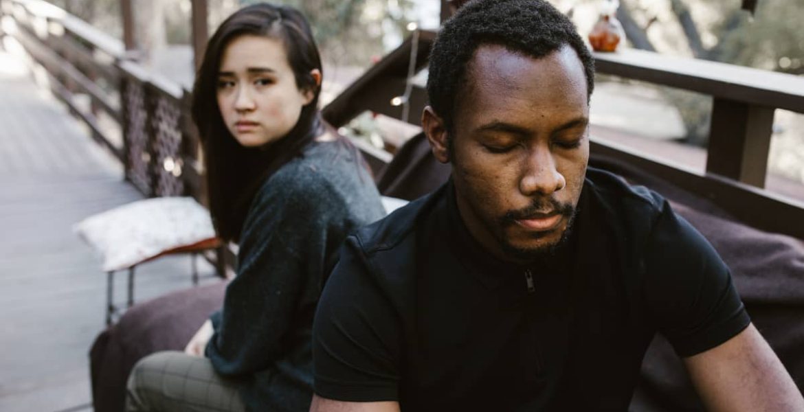 foto de una pareja distanciada en un banco de una plaza
