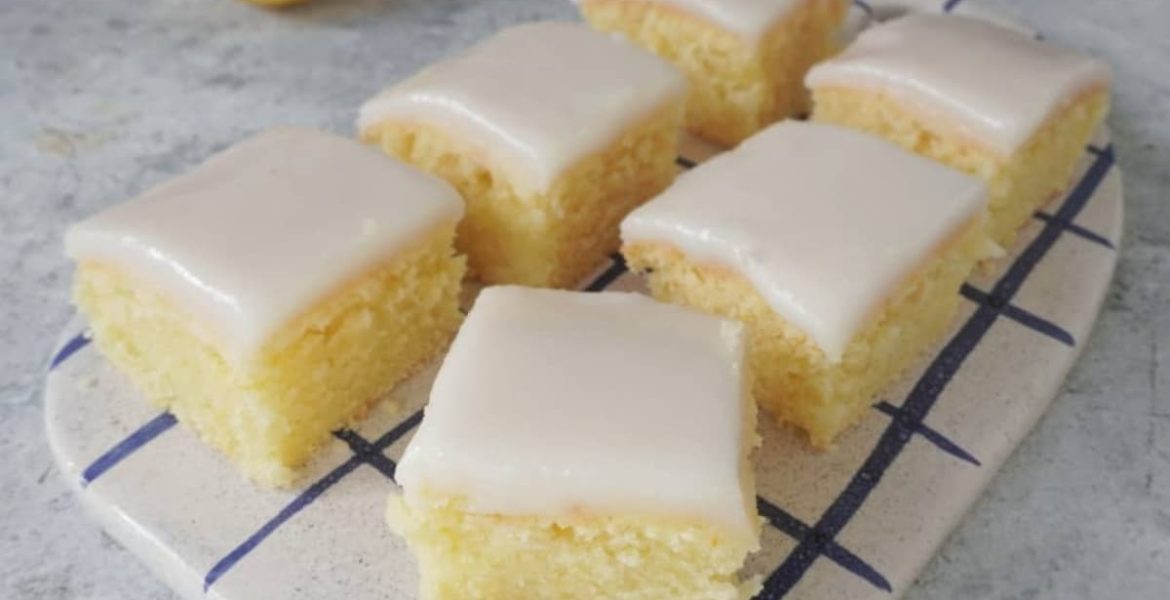 Cuadraditos de limón caseros con glasé de azúcar sobre una bandeja de madera