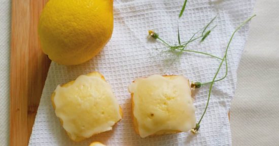 Cuadraditos de limón servidos con taza de té en una mesa de desayuno