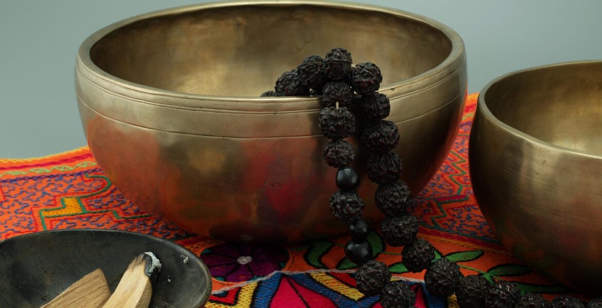 Palo santo encendido con humo, acompañado de resinas y frasco de aceite esencial sobre tabla de madera.
