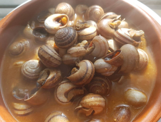Caracoles a la bordalesa servidos en su salsa tradicional.