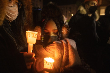 A mother and daughter attend a candlelight vigil