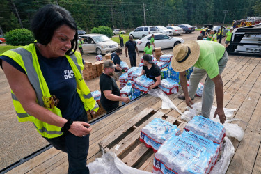 Jackson City firefighters and Humana volunteers help distribute more than 40,000 bottles of water and 3,000 MREs to Jackson, Miss., residents Sept. 2.