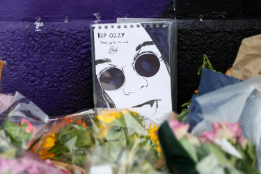 Flowers and a fan drawing at a memorial for Ozzy Osbourne.