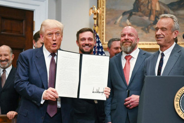Donald Trump, flanked by Robert F. Kennedy Jr. and others, shows executive order restarting the Presidential Fitness Test
