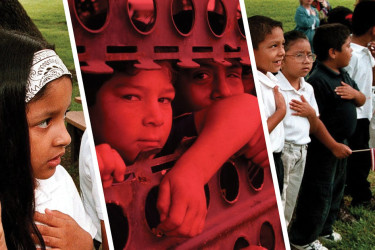 Young Latino children holding a small American flags.