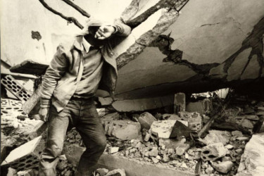 A man crying amidst the ruins of his house after a bombing.