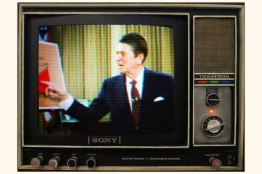 A television set pictures Ronald Reagan gesturing towards a graph.