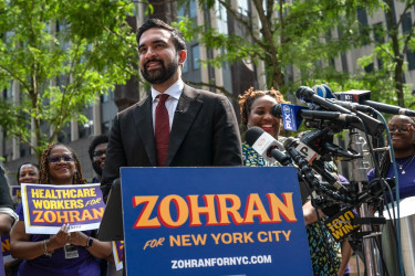 Zohran Mamdani stands at the podium during a campaign rally.