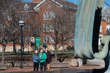 Students use the Clio history app at Marshall University to learn about a public art piece.