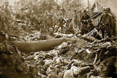 US soldiers posing with the bodies of Moro people after the massacre of Bud Dajo, Jolo Island, Philippines, March 7, 1906.