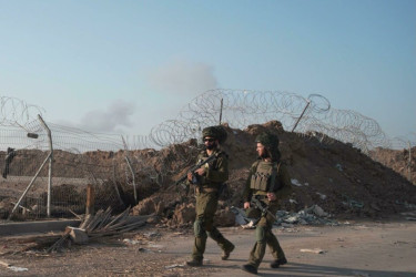 Israeli soldiers patrol along a destroyed fence near the Gaza Strip.