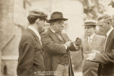Theodore Roosevelt speaking with three reporters.