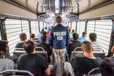 ICE officer on a bus full of detainees.