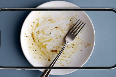 A smartphone screen shows a fork on a finished plate.