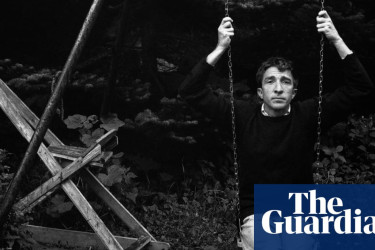 John Updike in 1962 sitting on an old swing.