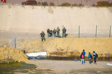 Migrants and Border Patrol agents at US-Mexico border