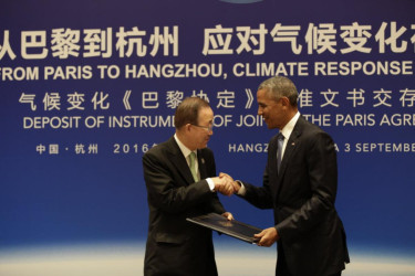 Obama hands the Paris Agreement documents to United Nations Secretary-General Ban Ki-moon.