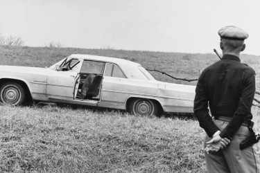 Police officer looking at Viola Liuzzo’s car after the march from Selma to Montgomery.