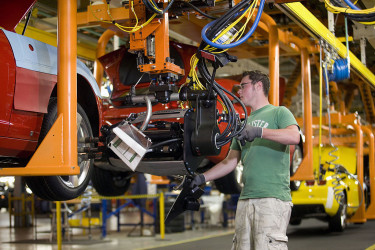 A worker assembling an automobile.