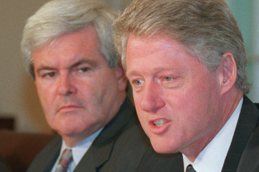 House Speaker Newt Gingrich listens as President Clinton.