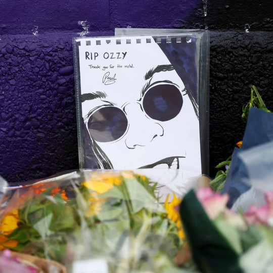 Flowers and a fan drawing at a memorial for Ozzy Osbourne.