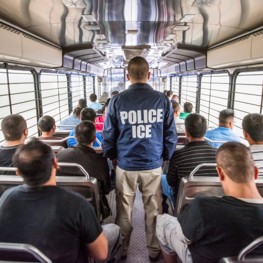 ICE officer on a bus full of detainees.
