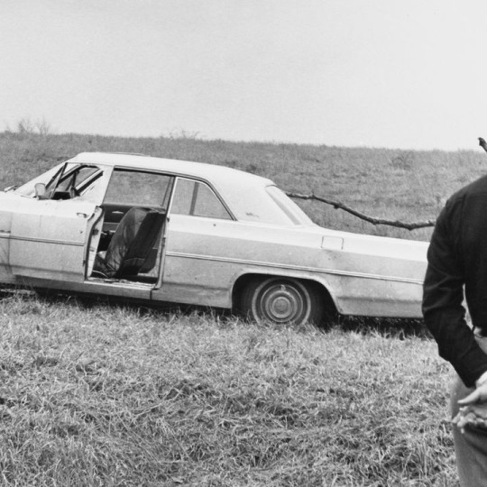Police officer looking at Viola Liuzzo’s car after the march from Selma to Montgomery.