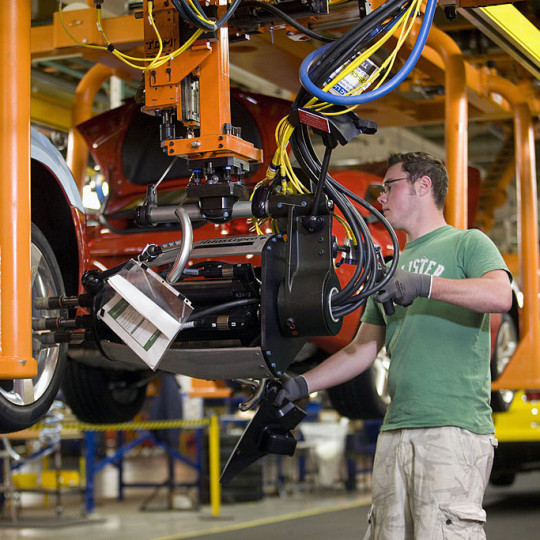 A worker assembling an automobile.