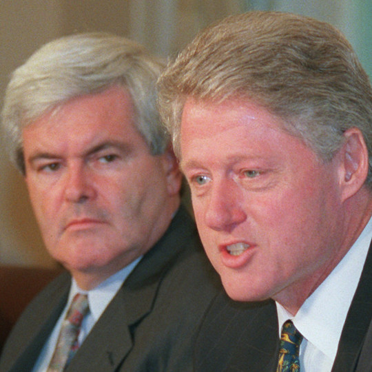 House Speaker Newt Gingrich listens as President Clinton.