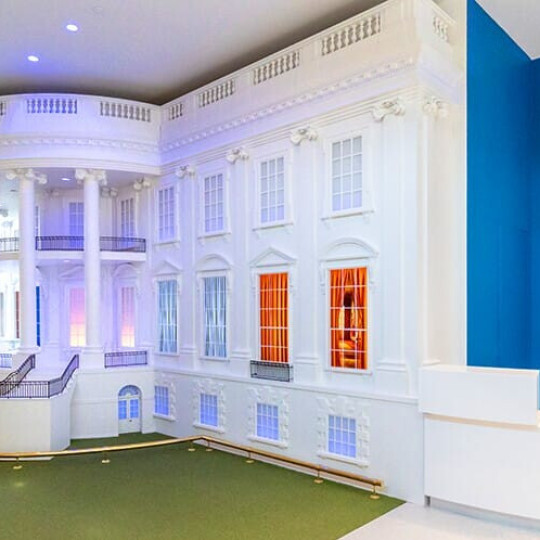 A model of the front of the White House in a museum exhibit.