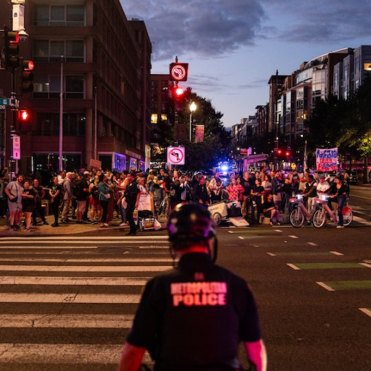 A Metropolitan Police Department officer watching demonstrators during a “Free D.C.” protest, Washington, D.C., August 2025.