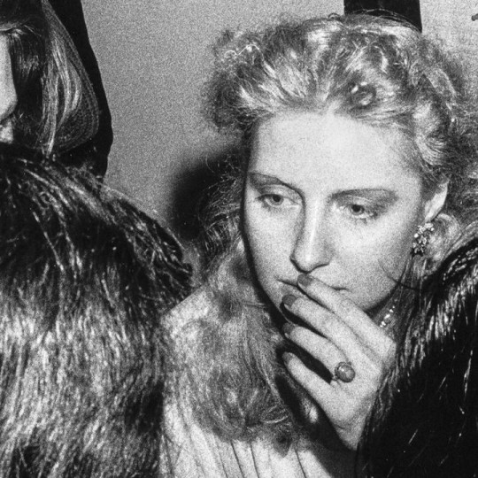 Black and white photograph of Shere Hite talking to three other women.